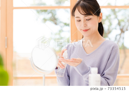 化粧水を手にとる若い女性 73354515
