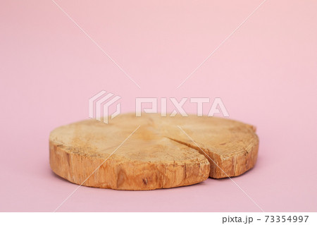 Wood slab texture. Large circular piece of wood cross section on pink background. Round piece of wood 73354997