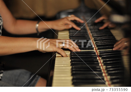 Old fortepiano with female woman hands, close up. Hands of a girl on the piano keys. 73355590