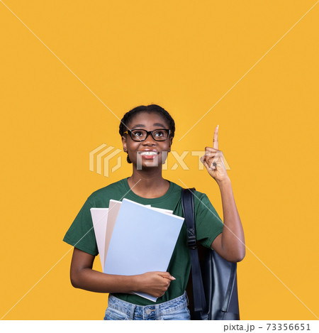 African Student Woman Pointing Finger Up Having Idea, Yellow Background 73356651