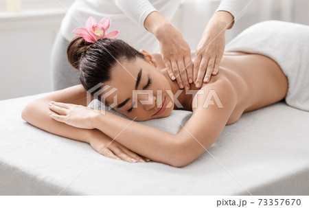 Spa Massage. Young Asian Woman Relaxing While Professional Therapist Massaging Her Shoulders 73357670