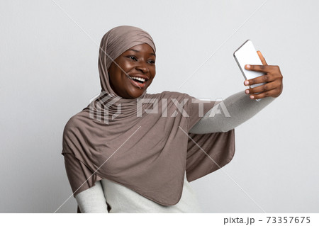 Joyful Black Muslim Lady In Hijab Taking Selfie On Smartphone 73357675