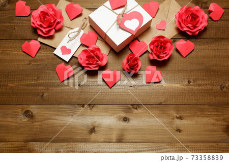 Love, Valentine's, women's day, relations, romantic design with gifts and envelope, wrapped in brown craft paper, tied with twine with bows, labels, handmade paper roses and hearts on wooden boards Love, Valentine's, women's day, relations, romantic design with gifts and envelope, wrapped in brown craft paper, tied with twine with bows, labels, handmade paper roses and hearts on wooden boards 73358839