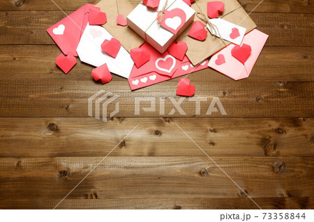 Love, Valentine's, women's day, relations, romantic template from gifts and love letters, colored and wrapped in craft paper, tied with twine with bows and labels, hearts on wood background Love, Valentine's, women's day, relations, romantic template from gifts and love letters, colored and wrapped in craft paper, tied with twine with bows and labels, hearts on wood background 73358844