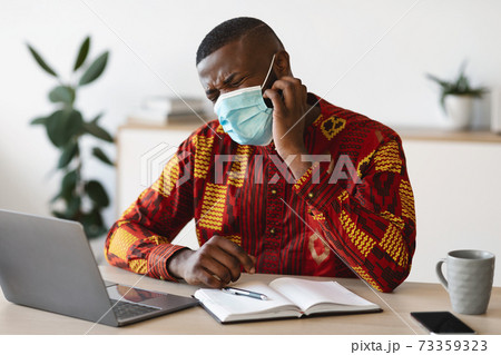 Stressed Black Man In Protective Medical Mask Scratching Face, Having Itchy Skin 73359323