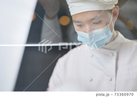 Thoughtful Asian cook being concentrated on work 73360970