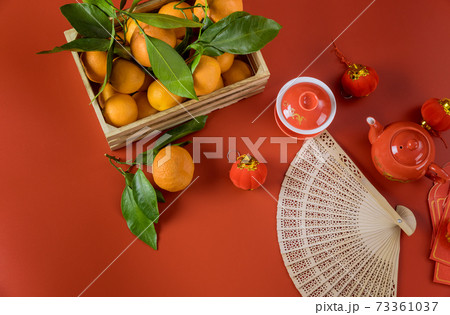 Lunar Happy Chinese New Year celebrations with ceremony tea set on mandarin oranges a red background Lunar Happy Chinese New Year celebrations with ceremony tea set on mandarin oranges a red background 73361037