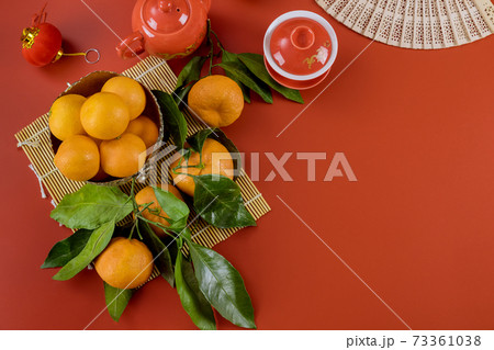 Asian Lunar New Year celebrations with ceremony tea set on bamboo and mandarin oranges a red background 73361038