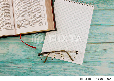 Opened the Holy Bible close up prayer time in eyeglasses on notepad Opened the Holy Bible close up prayer time in eyeglasses on notepad 73361102
