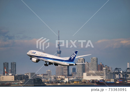 羽田空港第2ターミナルを離陸したana機と東京スカイツリー の写真素材