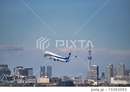 羽田空港第2ターミナルを離陸したana機と東京スカイツリー の写真素材