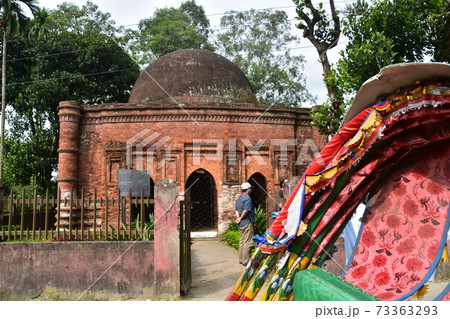 バングラデシュのダッカのショナルガオ　歴史的なゴアルディ・モスジットと停車中のリキシャと観光する男性 73363293