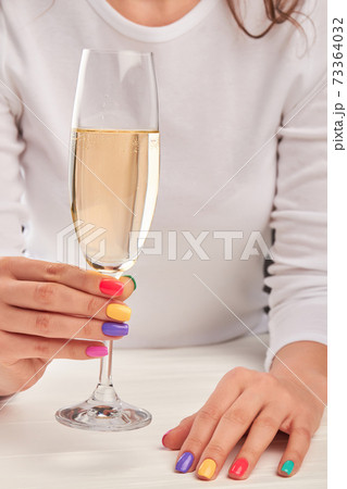 Young woman hands with glass of champagne. 73364032
