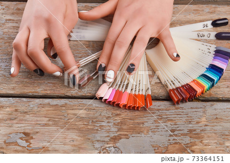 Young woman hands choosing nail color. 73364151