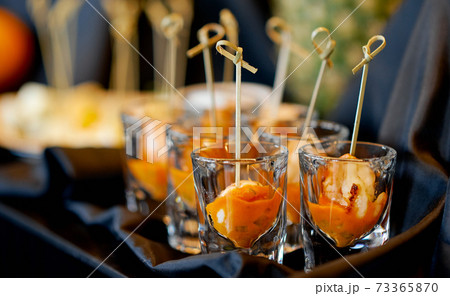 orange treats in a glass on a table with a cloth  73365870
