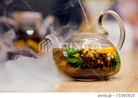 Transparent kettle filled with hot water stands in smoke Transparent kettle filled with hot water stands in smoke 73365910