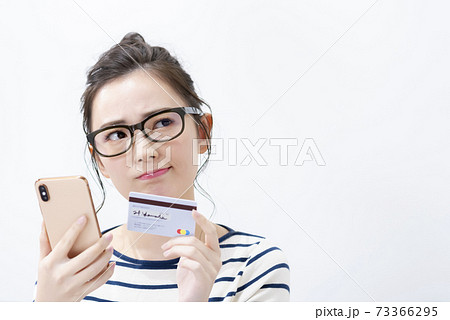 スマートフォンとカードを持つ若い女性 スマートフォンとカードを持つ若い女性 73366295
