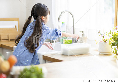 食器洗いのお手伝いをする女の子 73368483