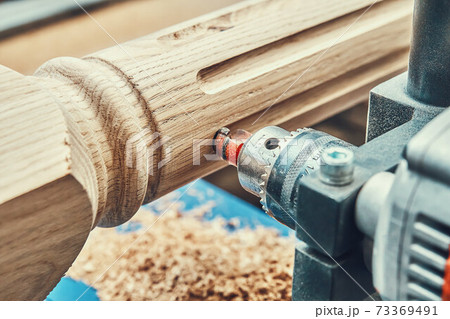 Turning wooden stair balusters. Wood stair balusters manufacturing process on a turning lathe with milling cutter 73369491