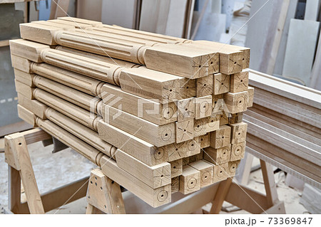 Turning wooden stair balusters. Wood stair balusters stacked in workshop Turning wooden stair balusters. Wood stair balusters stacked in workshop 73369847