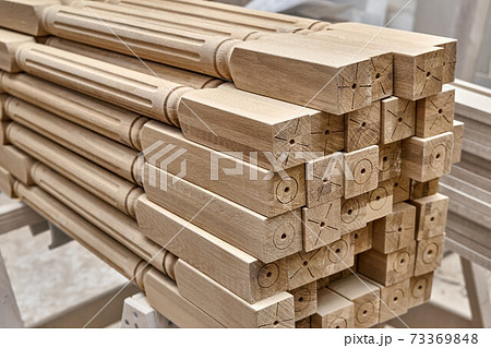 Turning wooden stair balusters. Wood stair balusters stacked in workshop Turning wooden stair balusters. Wood stair balusters stacked in workshop 73369848