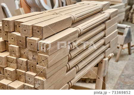 Turning wooden stair balusters. Wood stair balusters stacked in workshop Turning wooden stair balusters. Wood stair balusters stacked in workshop 73369852