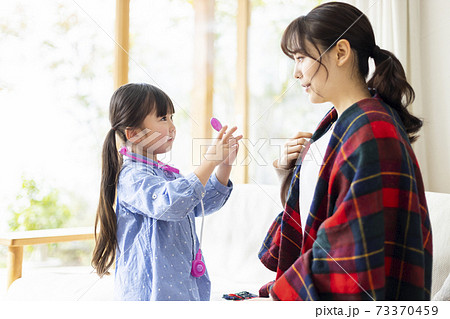 体調不良のママを心配する女の子 73370459