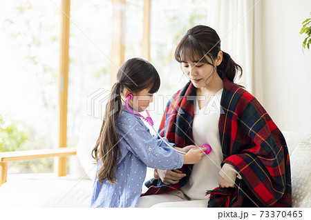 体調不良のママを心配する女の子 73370465