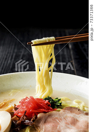 箸で持ち上げた豚骨ラーメン 73371366