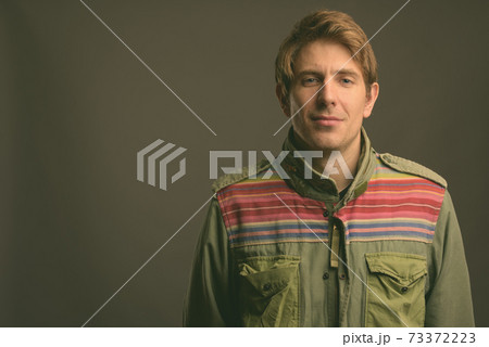 Handsome man against gray background Handsome man against gray background 73372223