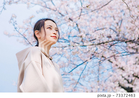 桜を見上げる若い女性 73372463