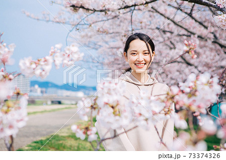 桜に囲まれる若い女性 73374326