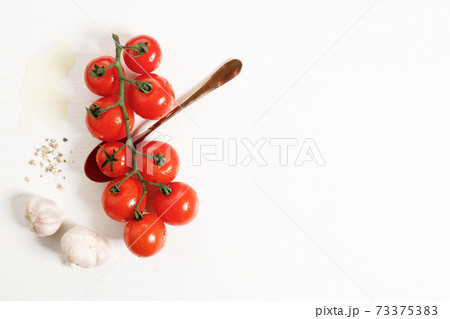 fresh red tomatoes with garlic on white wooden table. fresh red tomatoes with garlic on white wooden table. 73375383