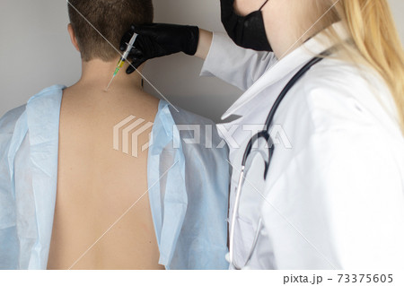 An allergist in the laboratory conducts an allergy prick-test. Skin test for household, food, epidermal allergic reactions. The test is performed on the patient back An allergist in the laboratory conducts an allergy prick-test. Skin test for household, food, epidermal allergic reactions. The test is performed on the patient back 73375605