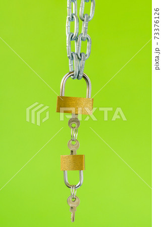 Padlocks with keys hanging on the metal chain Padlocks with keys hanging on the metal chain 73376126