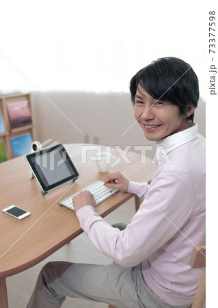 タブレットPCにキーボードを使う男性 タブレットPCにキーボードを使う男性 73377598