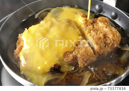 IHクッキングヒーターに対応している親子鍋でカツと玉ねぎを煮て卵でとじる調理シーン 73377836