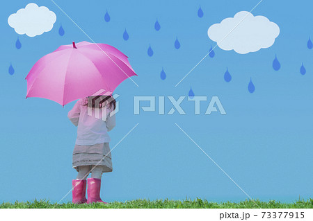 ピンクの傘と長靴の女の子の後ろ姿 雲と雨のしずくの写真素材
