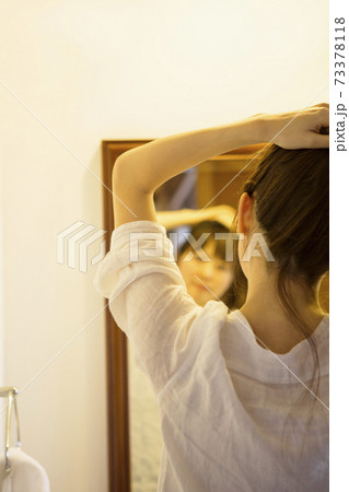 髪をまとめる女性の後ろ姿 髪をまとめる女性の後ろ姿 73378118