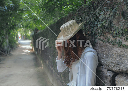 麦わら帽子をかぶる女性 73378213