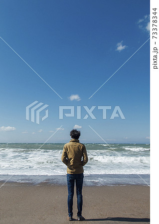 砂浜に立つ男性の後姿 砂浜に立つ男性の後姿 73378344
