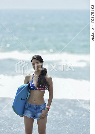 ボディボードを持つ水着女性 73379232