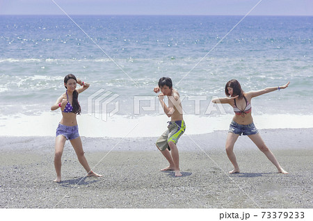 海辺でポーズをとる若者3人 73379233