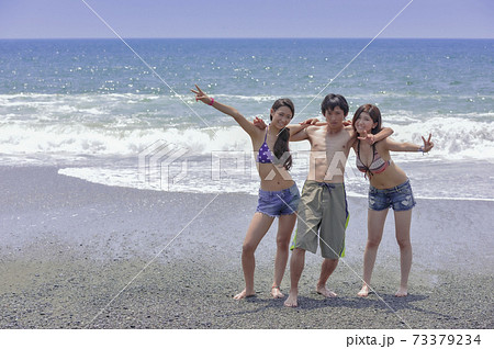 海辺でポーズをとる若者3人 73379234