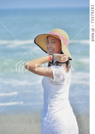 海辺で帽子をかぶる女性 海辺で帽子をかぶる女性 73379261