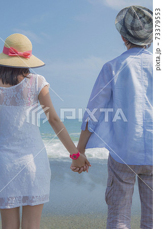海辺で手をつなぐカップルの後ろ姿 海辺で手をつなぐカップルの後ろ姿 73379553
