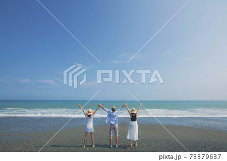 海辺でポーズをとる若者3人の後ろ姿 海辺でポーズをとる若者3人の後ろ姿 73379637