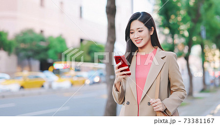 woman use smartphone outdoor 73381167