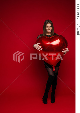 Heart shaped balloon in girl's arms. Saint 73381343