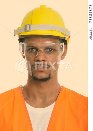 Face of young African man construction worker wearing protective glasses 73381378